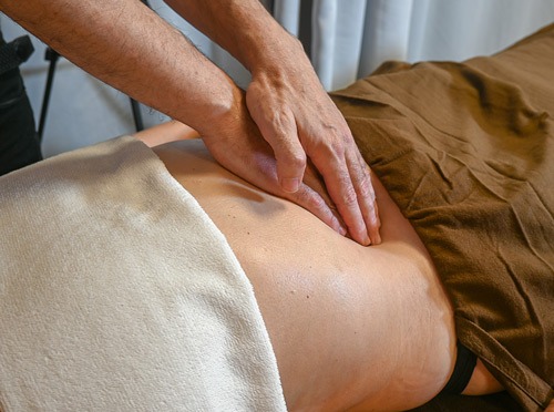 massage-du-ventre-chi-nei-tsang-bienfaits-relaxation Gros plan d'un massage du ventre Chi Nei Tsang, illustrant la relaxation profonde et la détoxification.